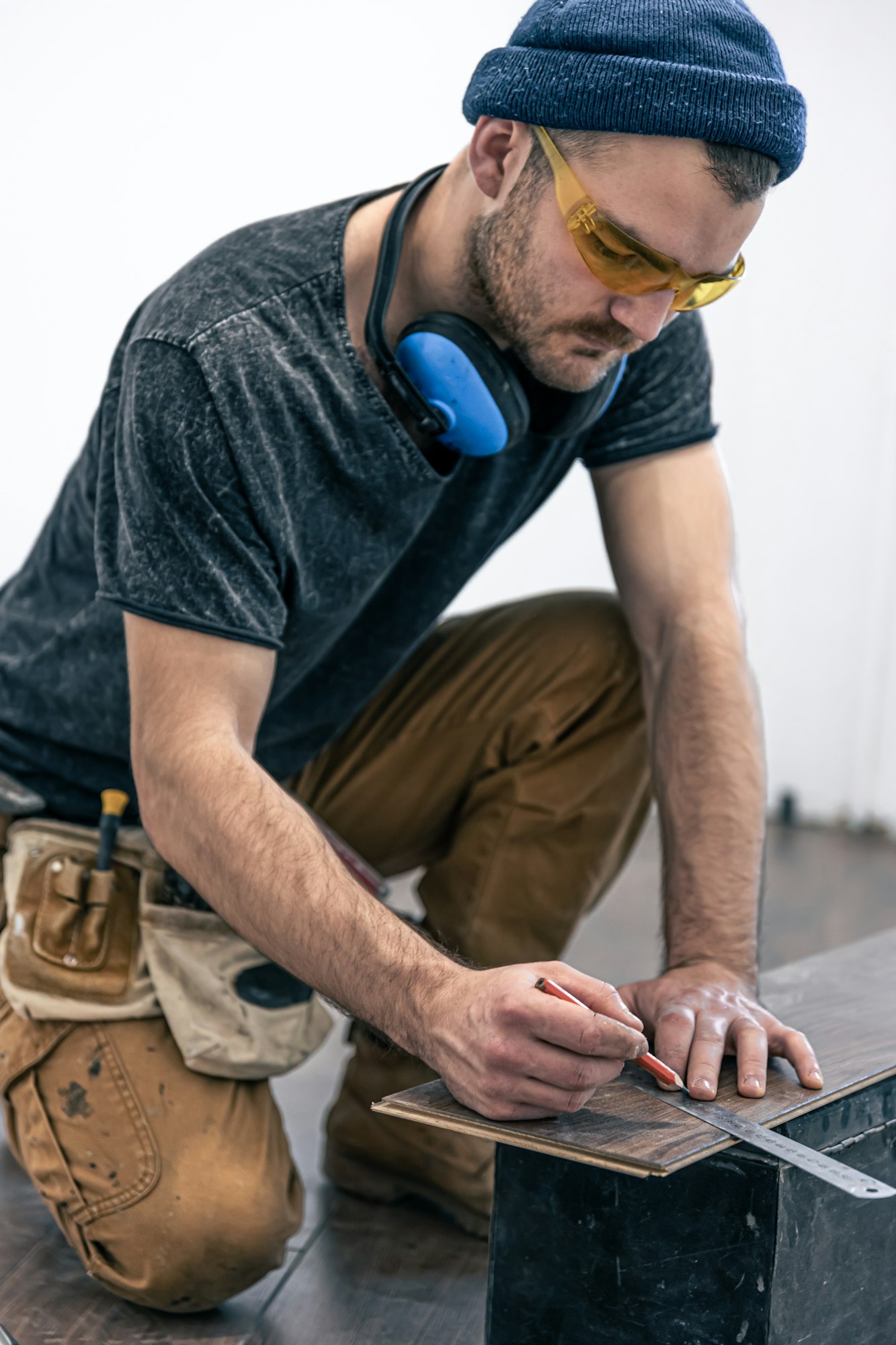 A male worker puts laminate flooring on the floor.